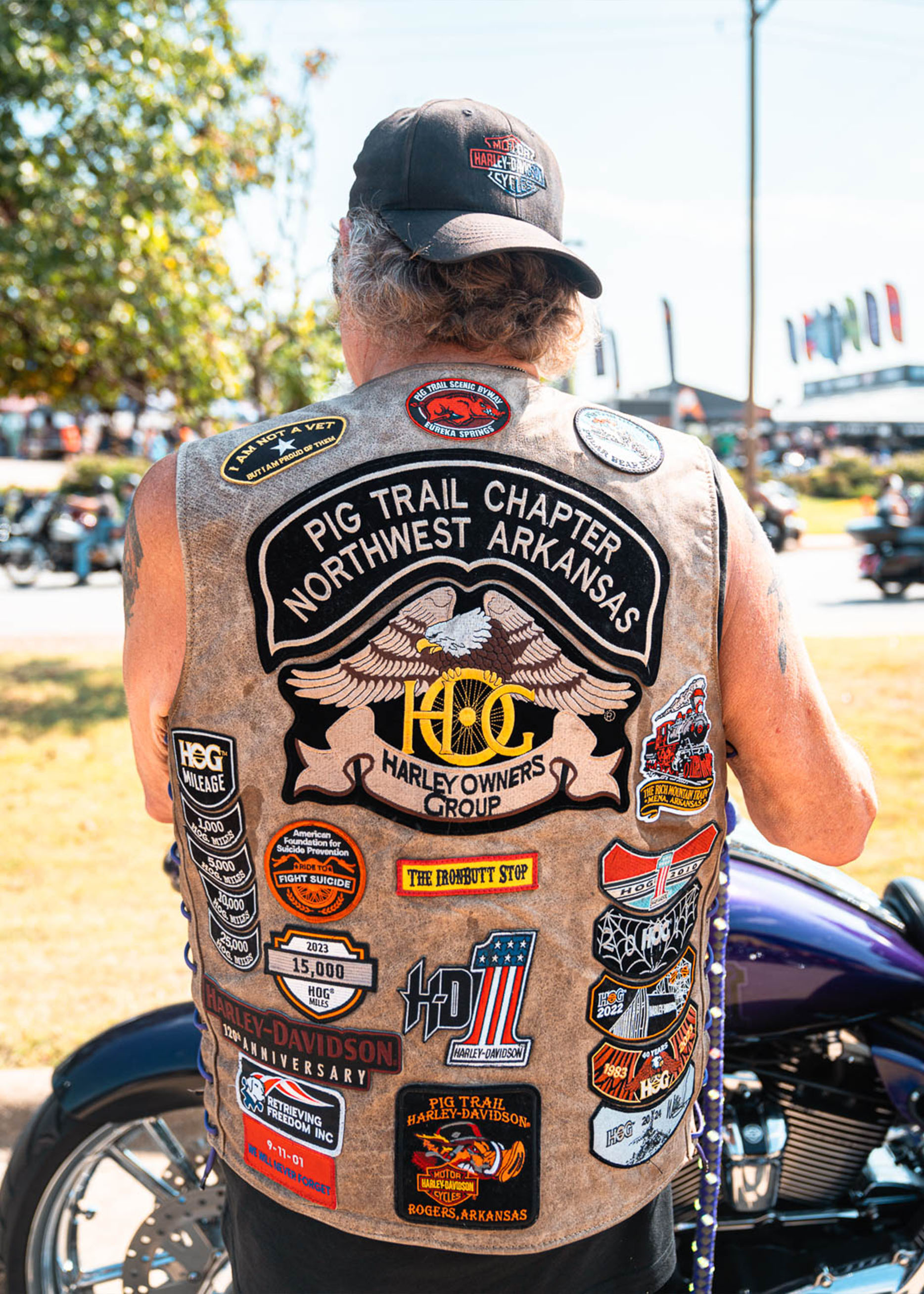 A man shows the back of his patch-sewn leather vest 