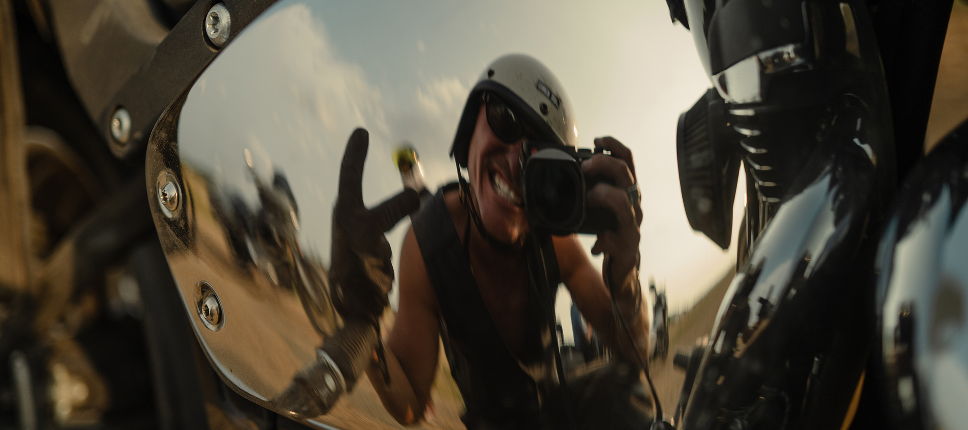 Close-up reflection self portrait in a motorcycle’s polished chrome surface of the stories photographer Ben Christensen