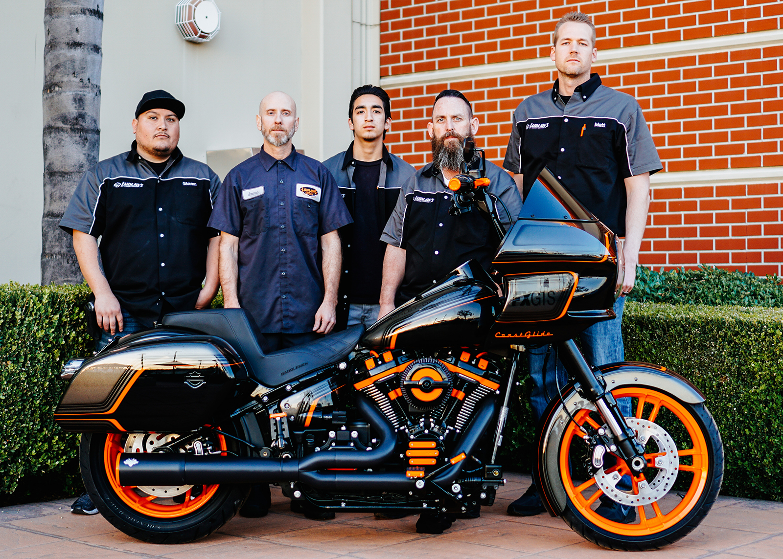  Laidlaw’s mechanics standing behind their custom built motorcycle, the Laidlaw Coastglide.