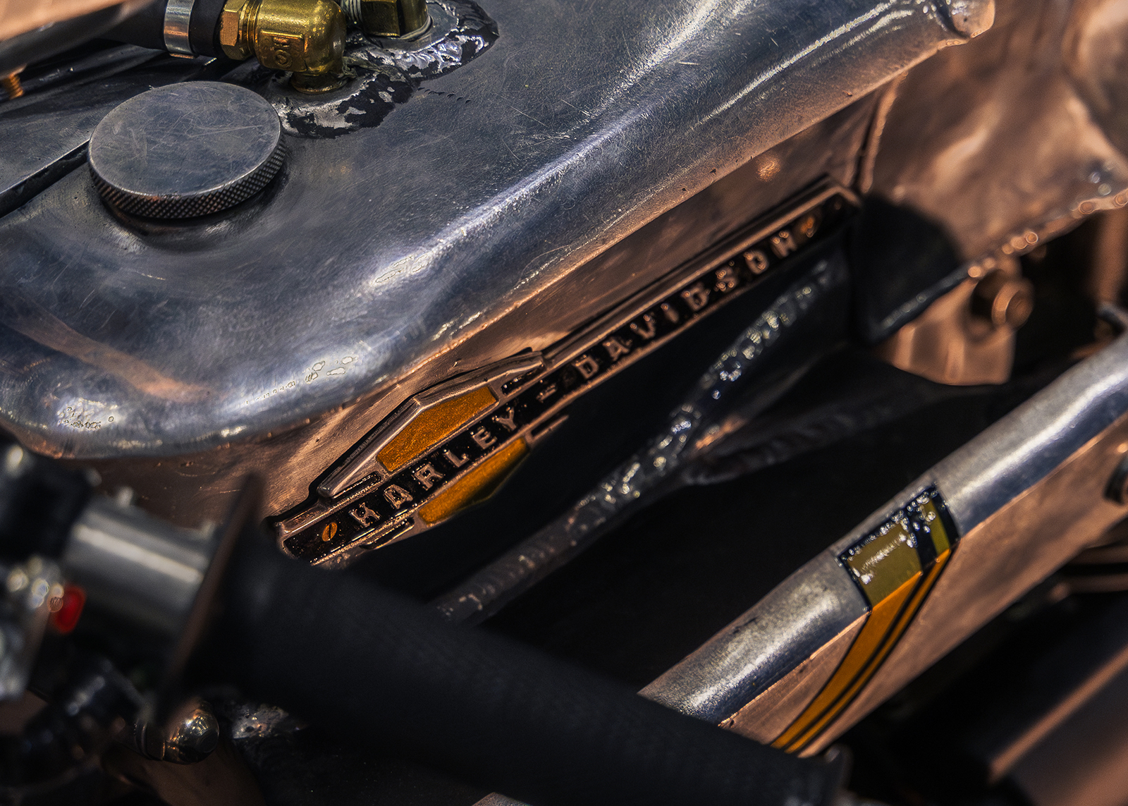 Close-up of a Harley-Davidson motorcycle engine with a raw metal finish, visible bolts, and engraved branding