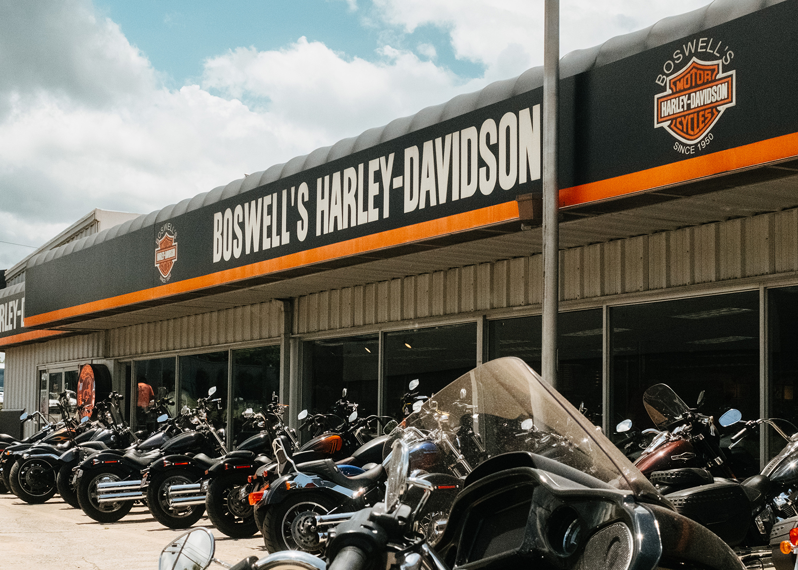 The exterior of Boswell’s Harley-Davidson dealership with a row of bikes parked out front.