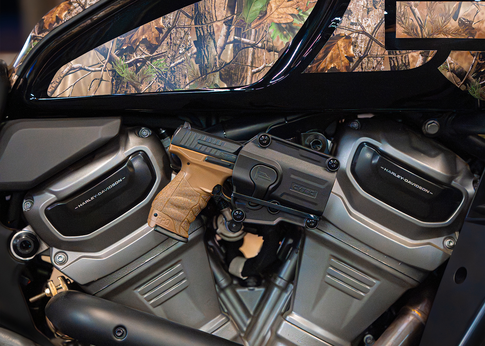 Close-up of a Harley-Davidson x Realtree Pan America with a mounted tactical pistol and camo accents.