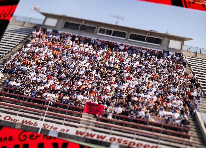 Large crowd of 2001 Route 66 riders fills grandstand seating at an outdoor venue, captured as a wide group photo