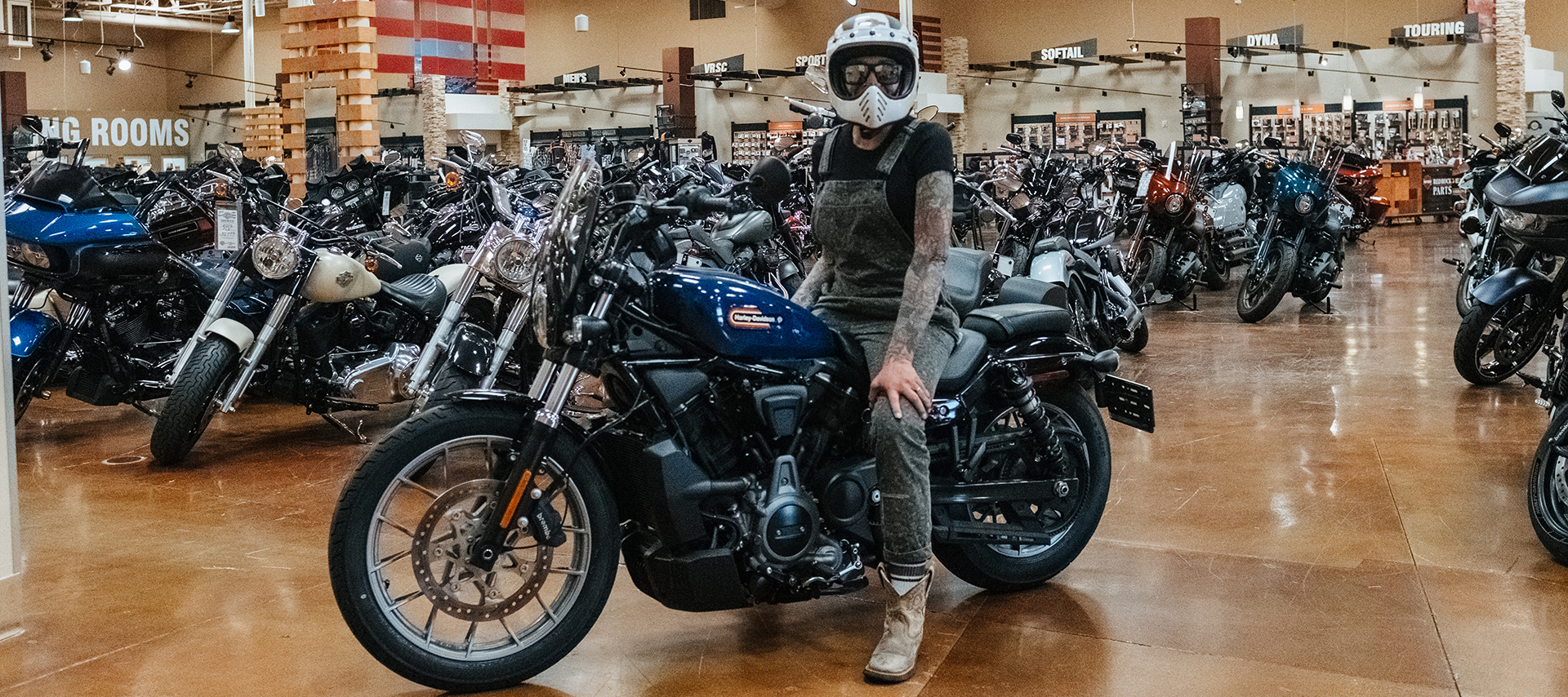 Red Rock Harley-Davidson’s community marketing manager Brandi Moya poses in a helmet on a motorcycle on the showroom floor.