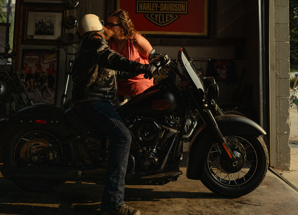Motorcyclist on a Harley-Davidson receives a goodbye kiss before setting out on an early morning ride