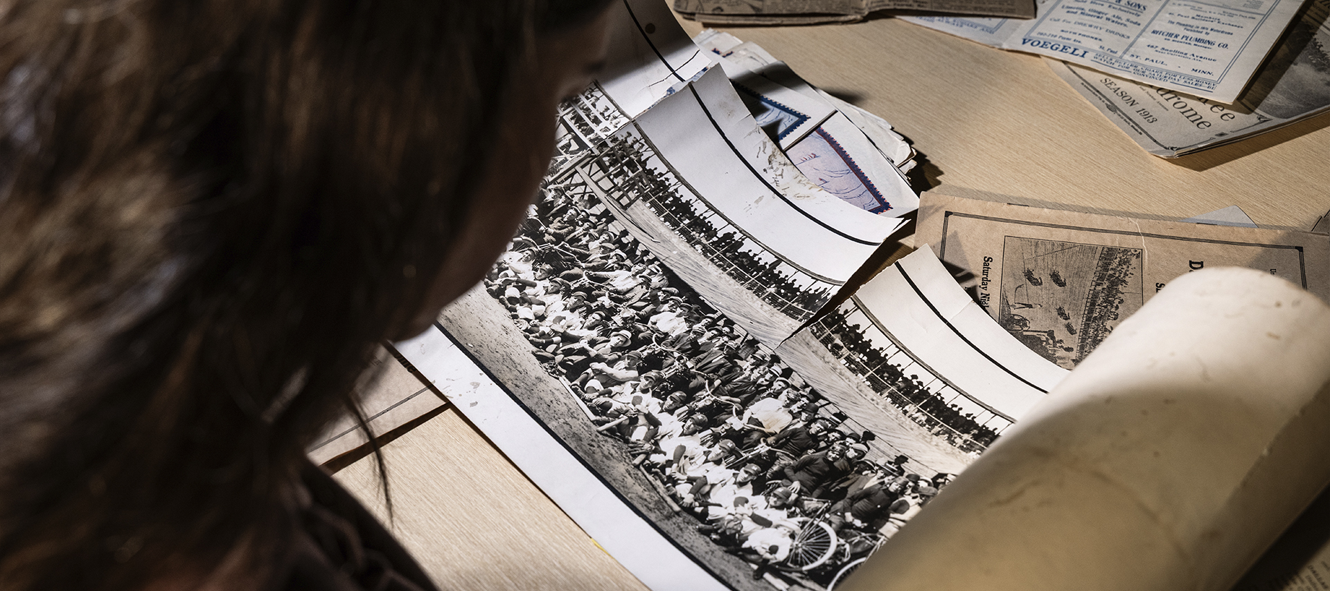 Looking over the shoulder of a Museum archivist at a panoramic photo taken at Tuileries Motordome in Denver on June 2, 1912