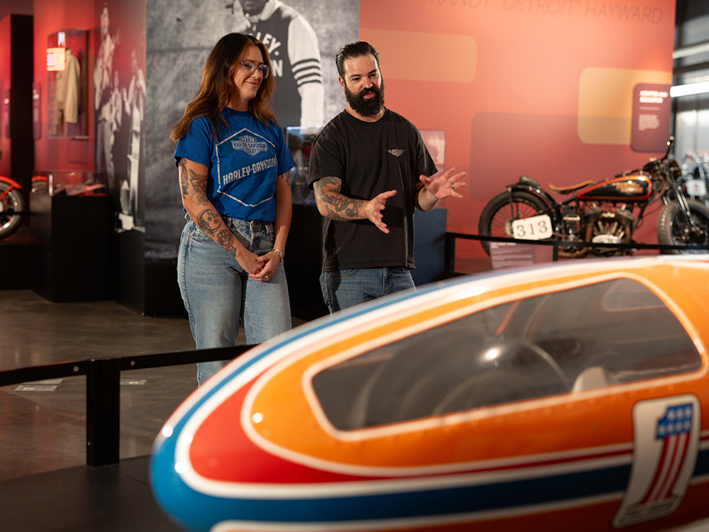 Two museum visitors viewing Harley-Davidson streamliner exhibit