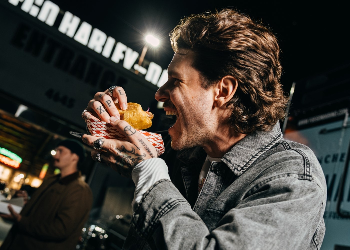 Persone che ridono e mangiano un panino a una Harley Night.