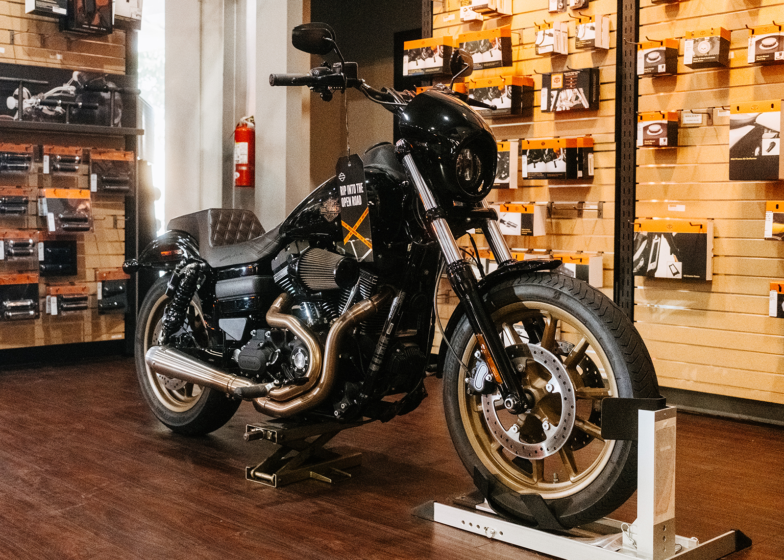 A Harley-Davidson Low Rider S on display in Moonshine Harley-Davidson’s showroom with riding accessories in the background.