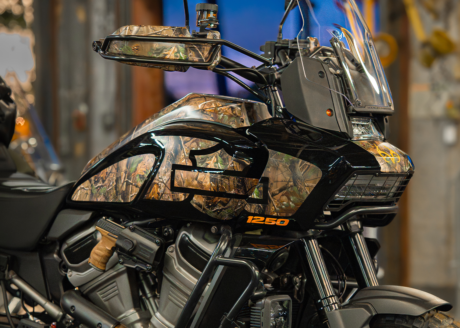 Custom Harley-Davidson x Realtree Pan America with camo graphics and off-road accessories on display.