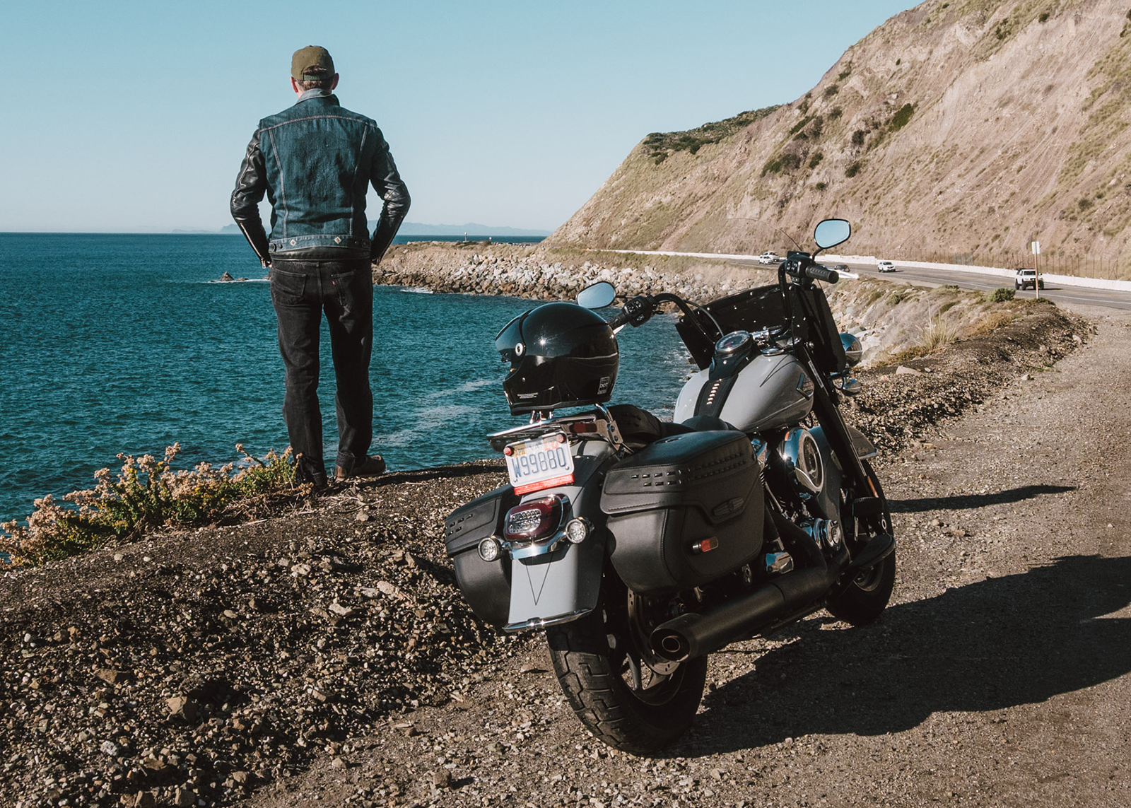 The author standing looking at the ocean on a coastal highway shoulder with his Harley-Davidson Heritage Classic parked nearby