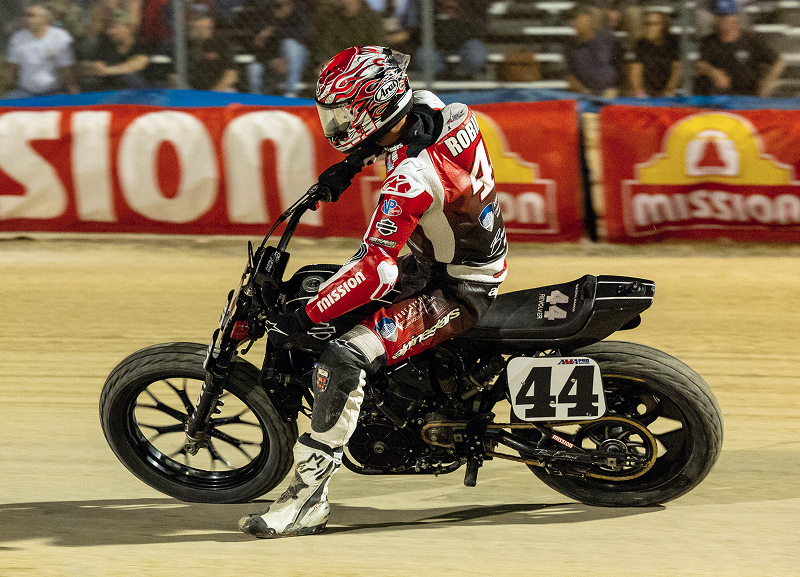 Brandon Robinson powers motorcycle #44 across the flat track under stadium lights during a race