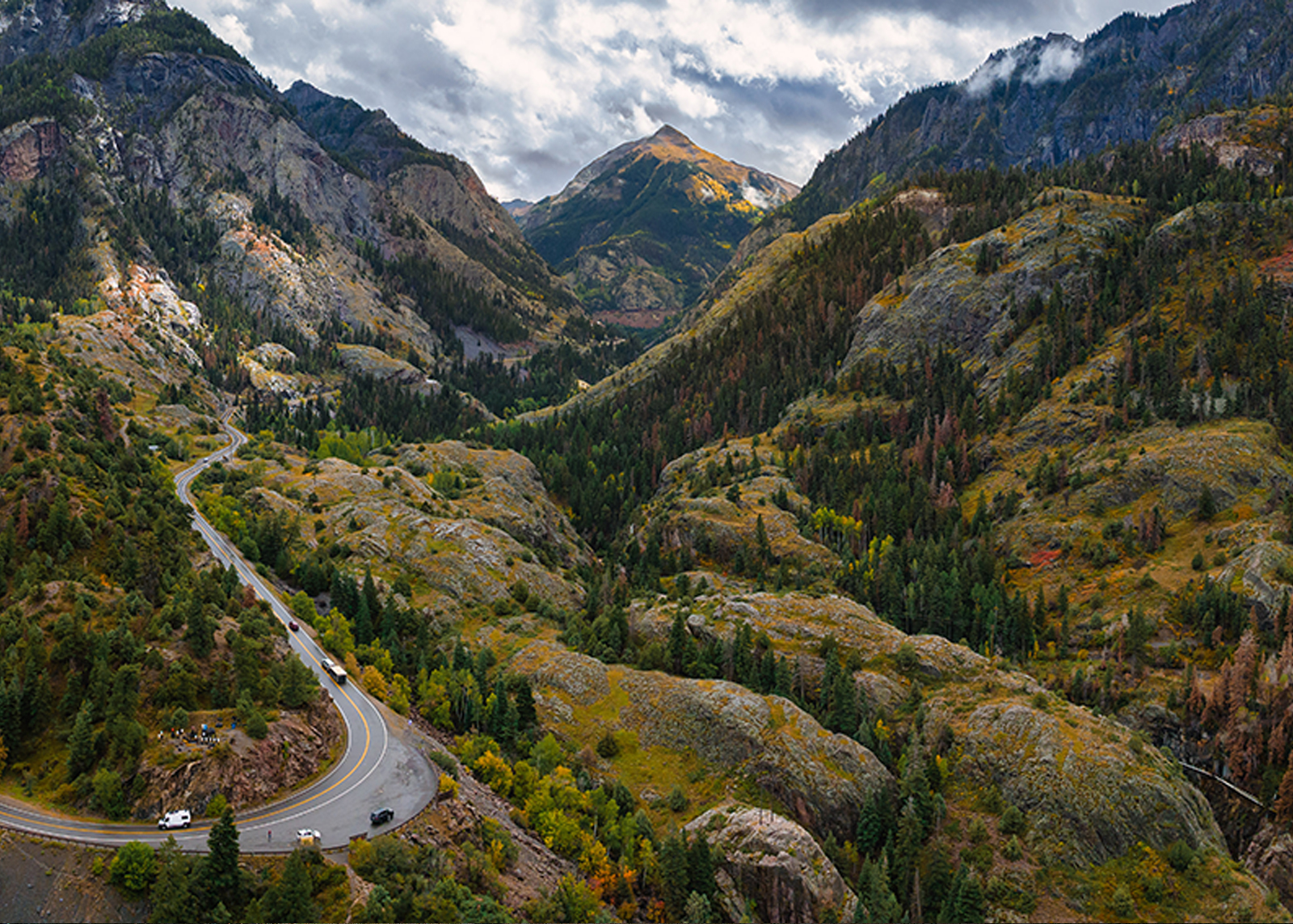 A scenic sweeping view of a curving road through the mountains 