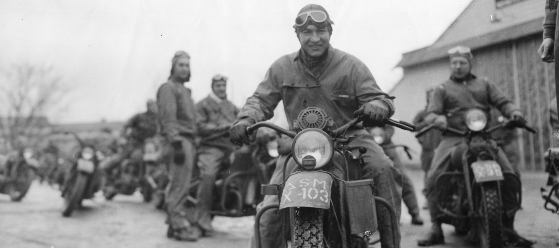 A soldier smiles while riding a Harley-Davidson