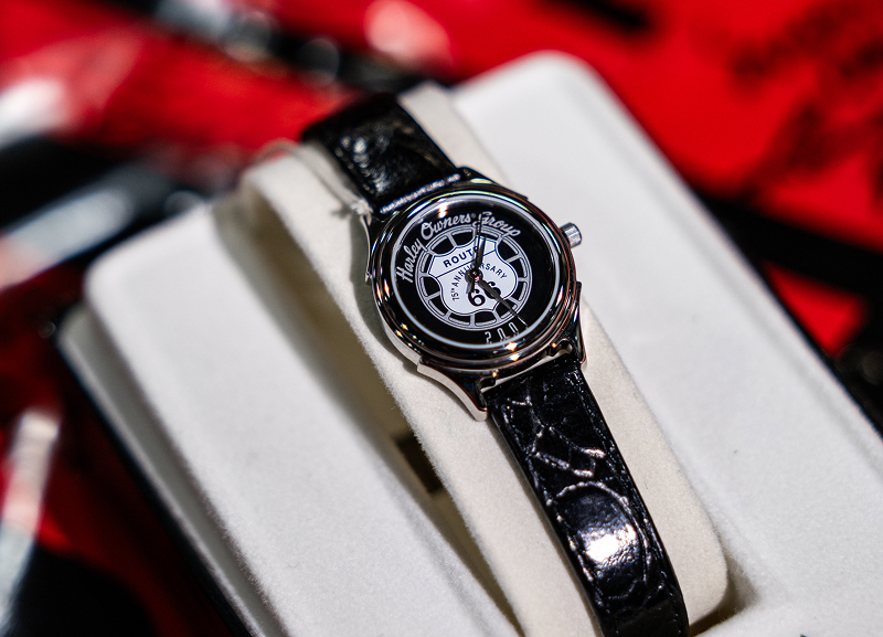 Close-up of a Harley Owners Group Route 66 2001 themed wristwatch displayed in a box, with a black leather strap