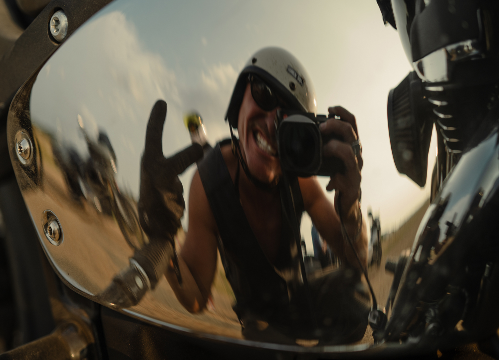 Close-up reflection self portrait in a motorcycle’s polished chrome surface of the stories photographer Ben Christensen
