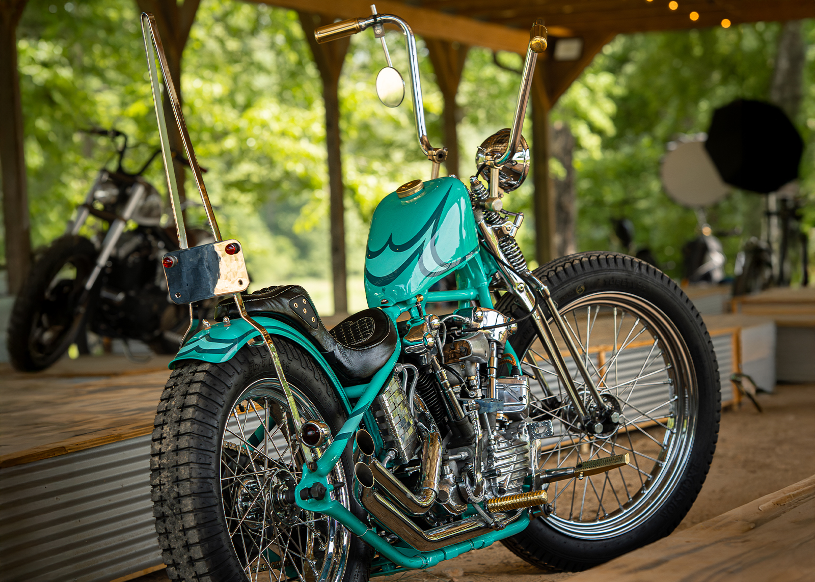 A closeup of a turquoise chopper, set up for viewing.