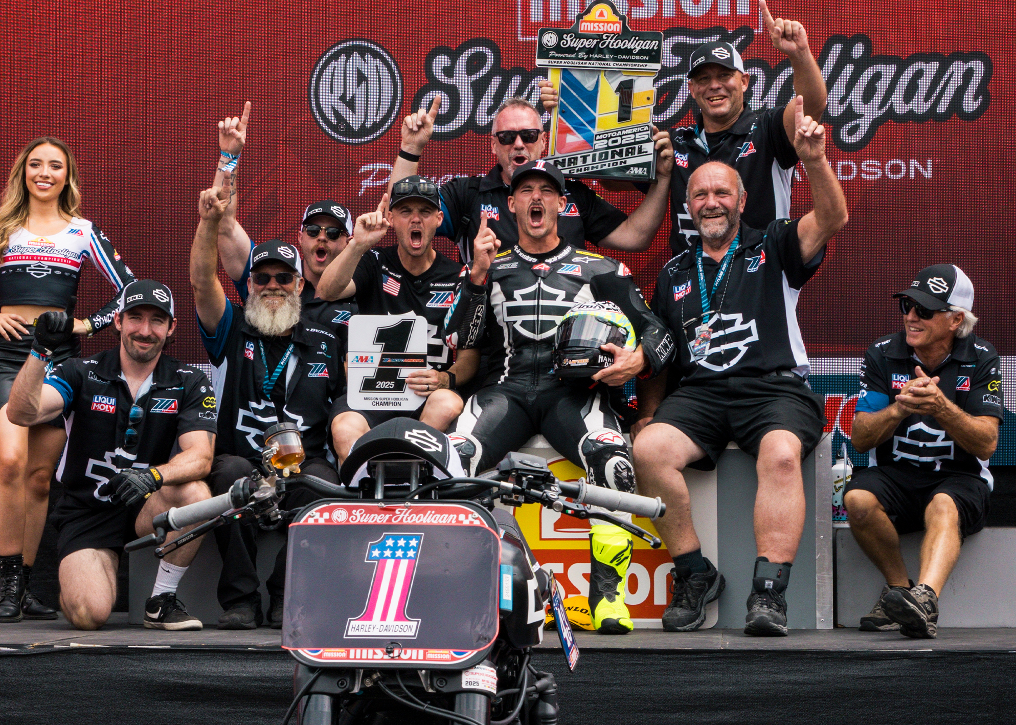 James Rispoli celebrates a first place finish alongside his Harley-Davidson Factory Racing team on the podium.