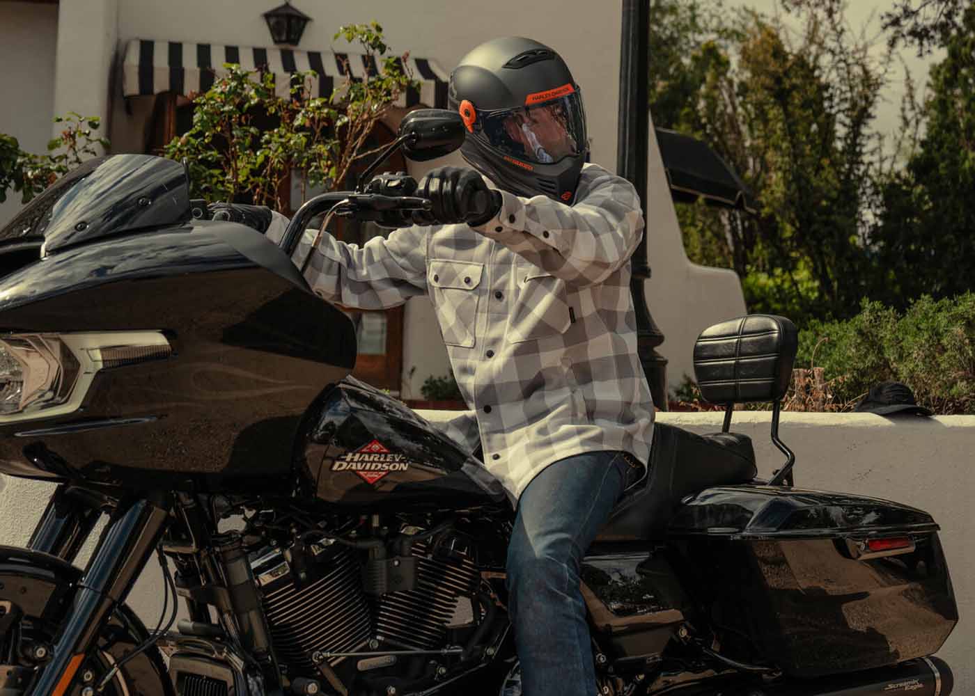 man wearing a plaid riding shirt sitting no H-D motorcycle