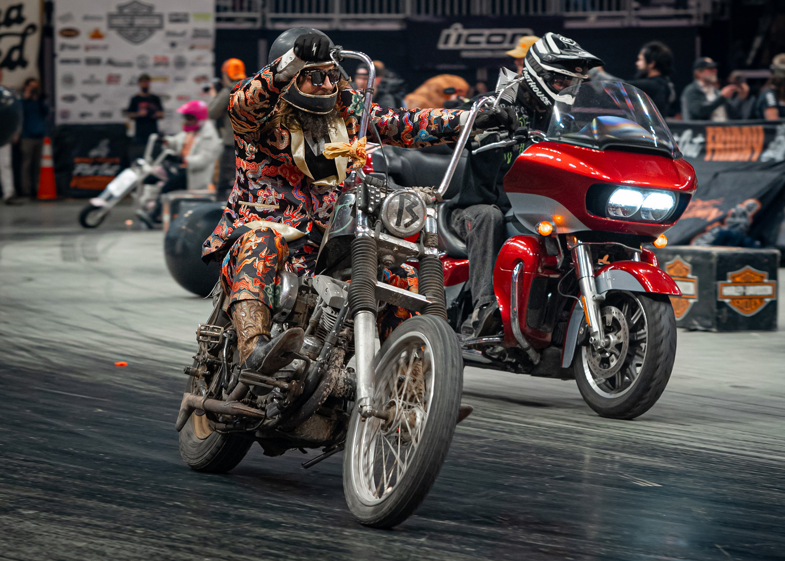 A man in a flamboyant suit rides his chopper around the indoor racetrack