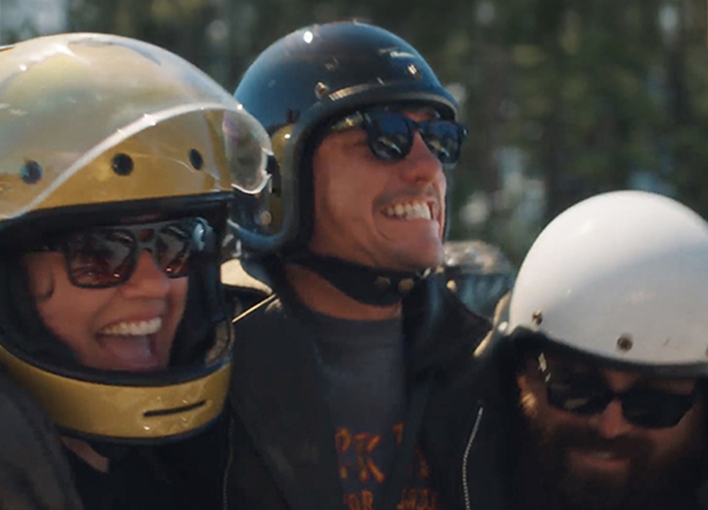 3 riders wearing helmets laughing