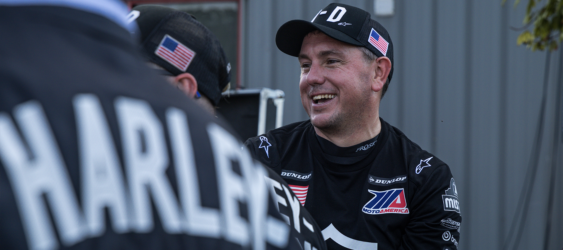Harley-Davidson Factory Racing Chief Race Mechanic Dave Hopkinson smiles while talking to other team members.