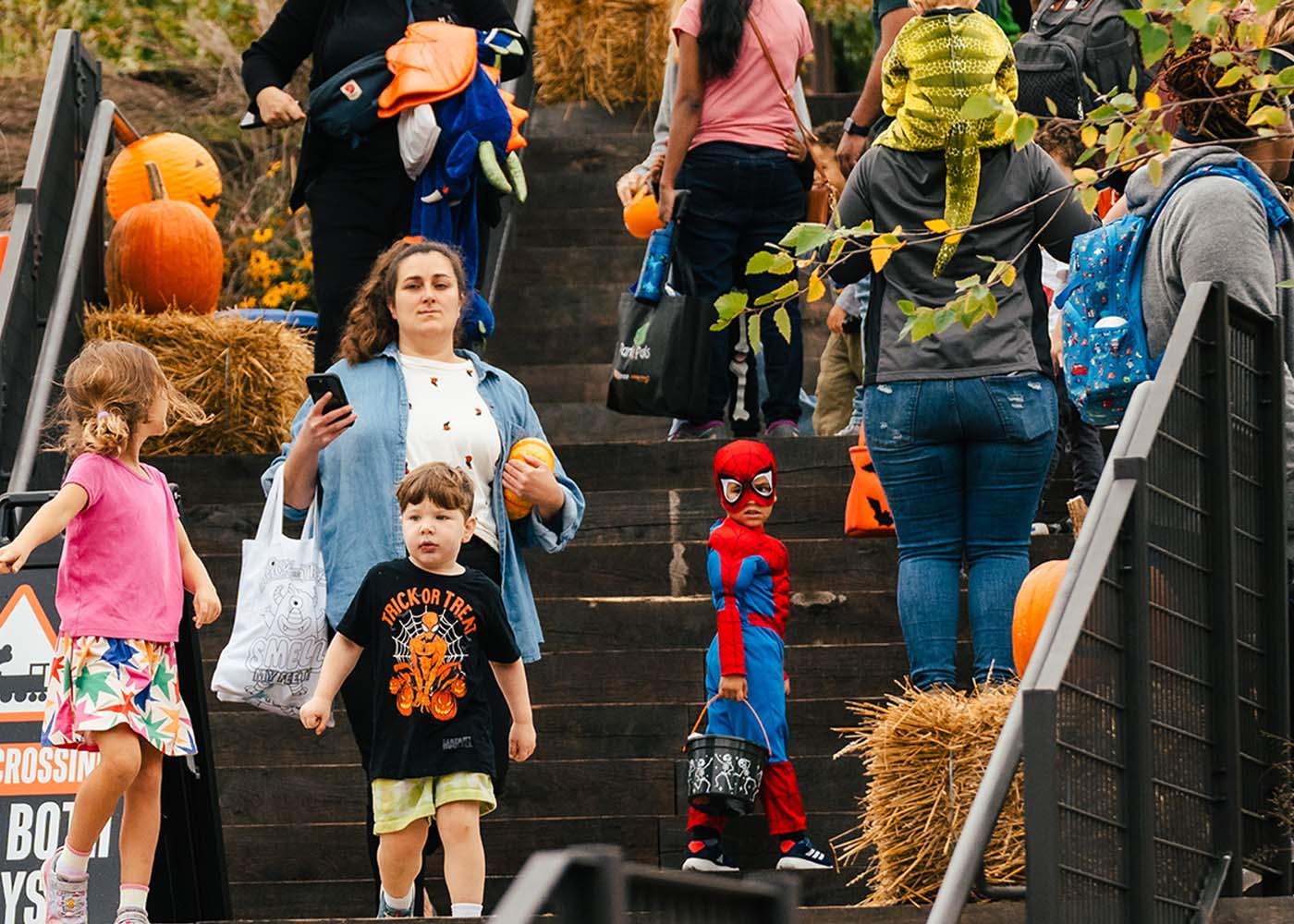 Families attending Halloween event with pumpkins and costumes