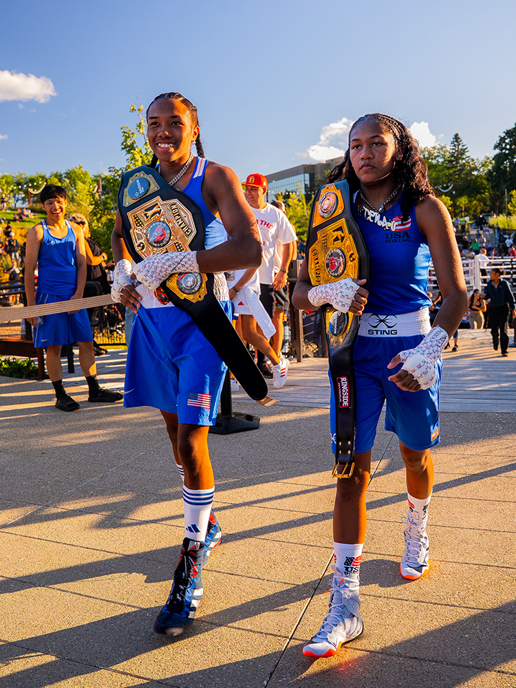 Youth boxing champions walking with title belts after match