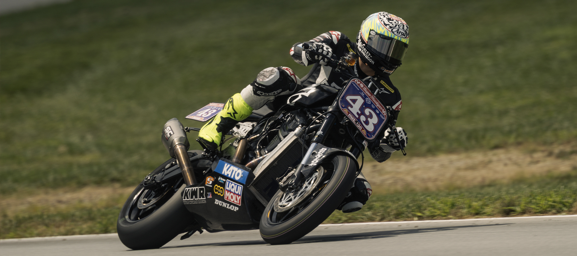 James Rispoli leans his Harley-Davidson #43 through a corner, captured in a low side-on action shot.