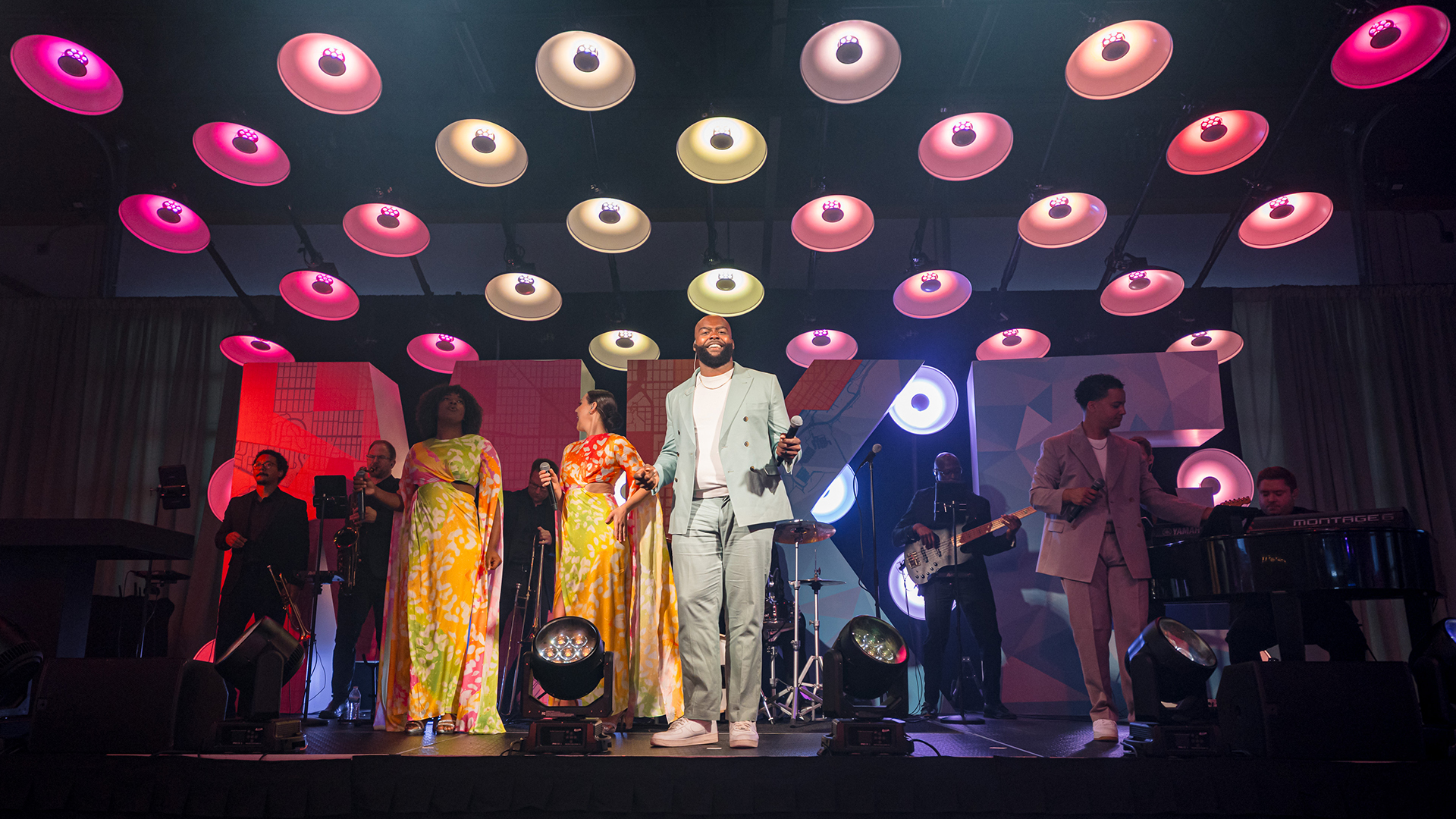 Live band performing on stage beneath colorful circular lights