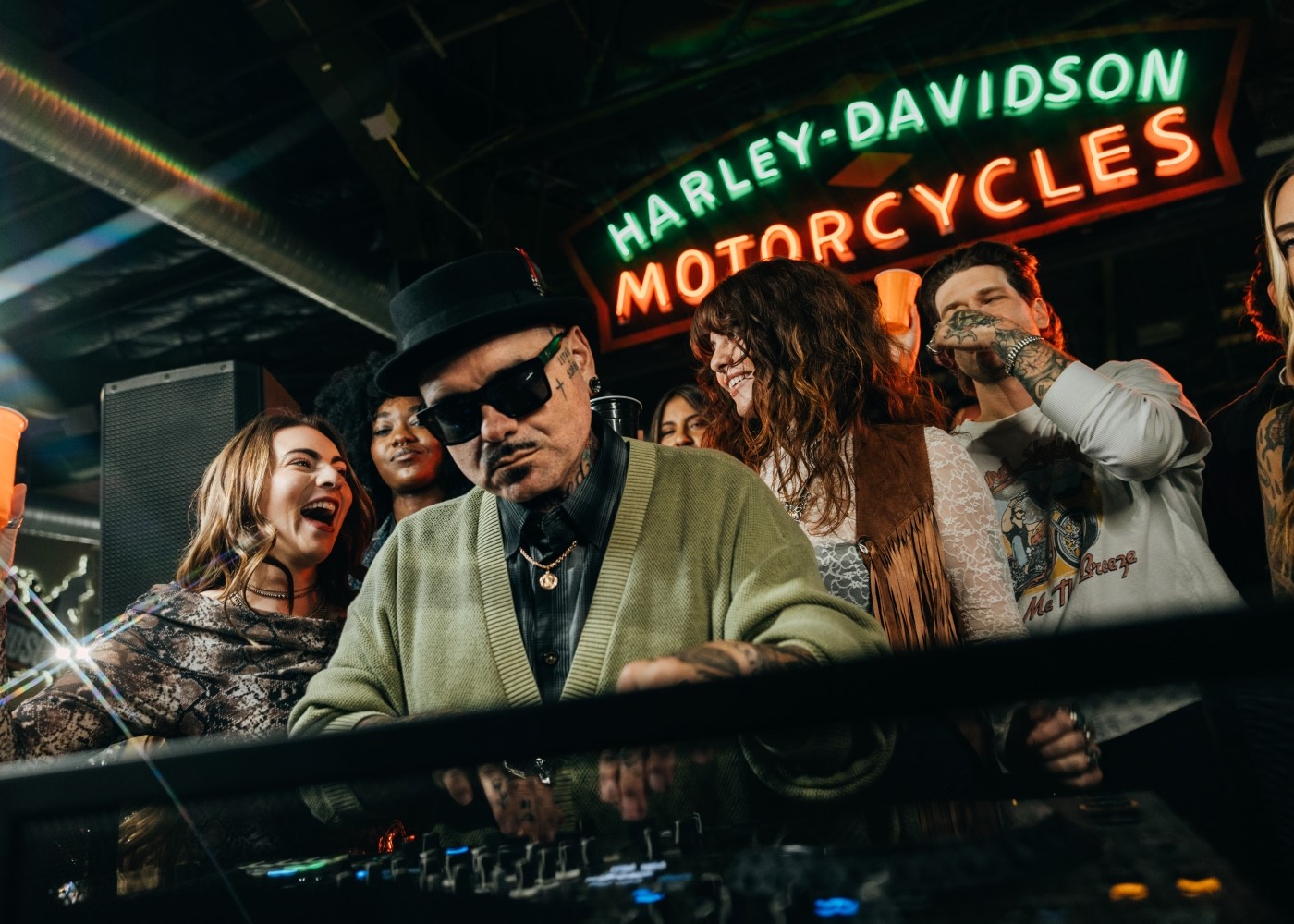 Un DJ che suona durante un evento delle Harley Nights mentre una folla intorno balla e festeggia.