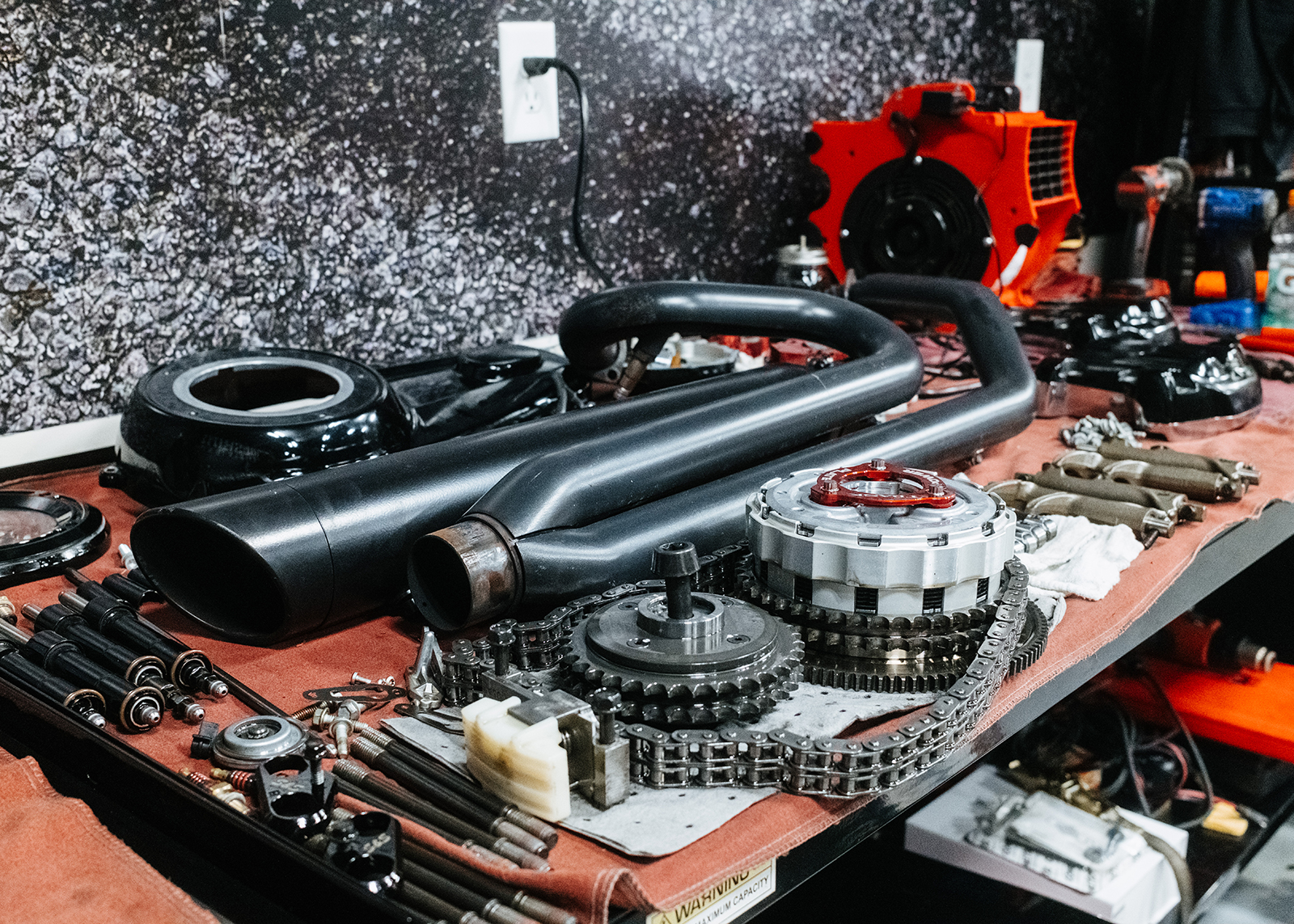 A variety of performance motorcycle parts on workshop table at Moonshine Harley-Davidson.