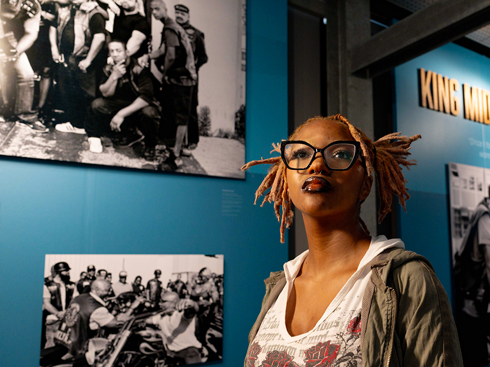 Visitor standing in museum gallery with historical photos on wall