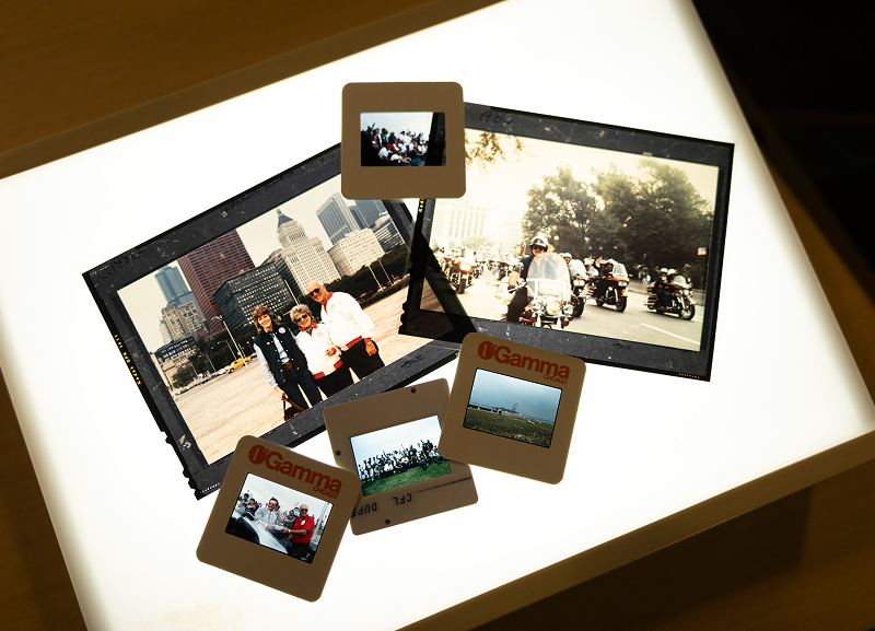 Light table displaying mounted slides and small photos showing motorcycle scenes from the Ride For Liberty