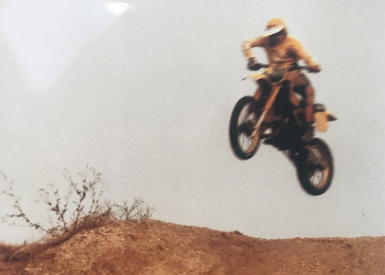 A vintage photo of Larry Altholtz mid-air during a motocross race in the 1980s.