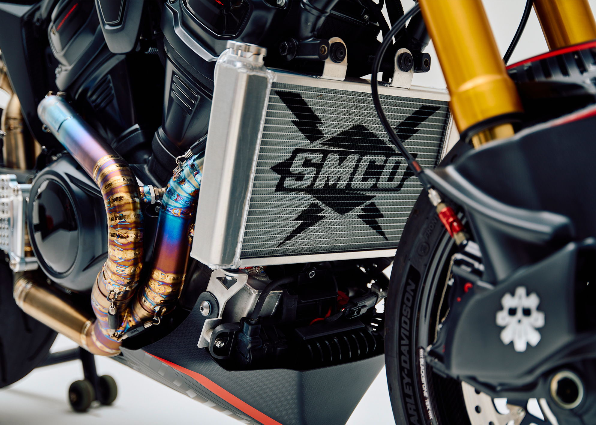 Close-up of the custom Pan America ST showing the engine, titanium exhaust, and radiator with SMCO’s logo on it.