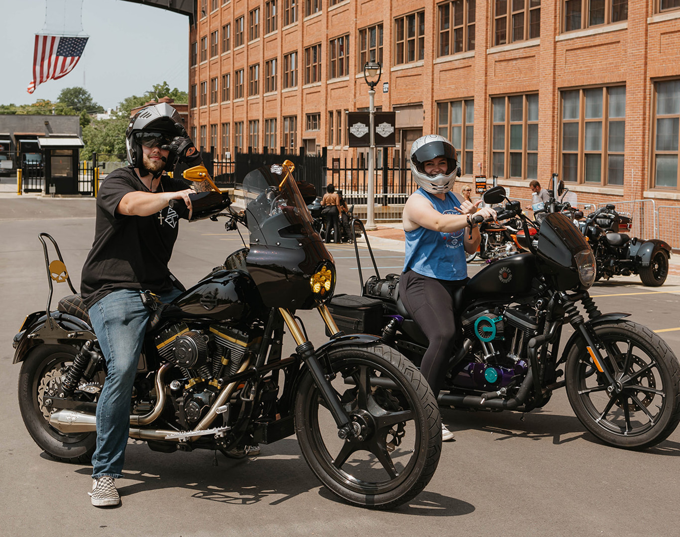 Man and woman on motorcycles in front of H-D Headquarters