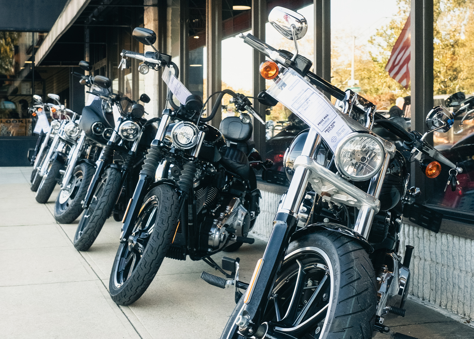 A row of Harley-Davidson motorcycles for sale parked in front of Harley-Davidson of Nassau County.