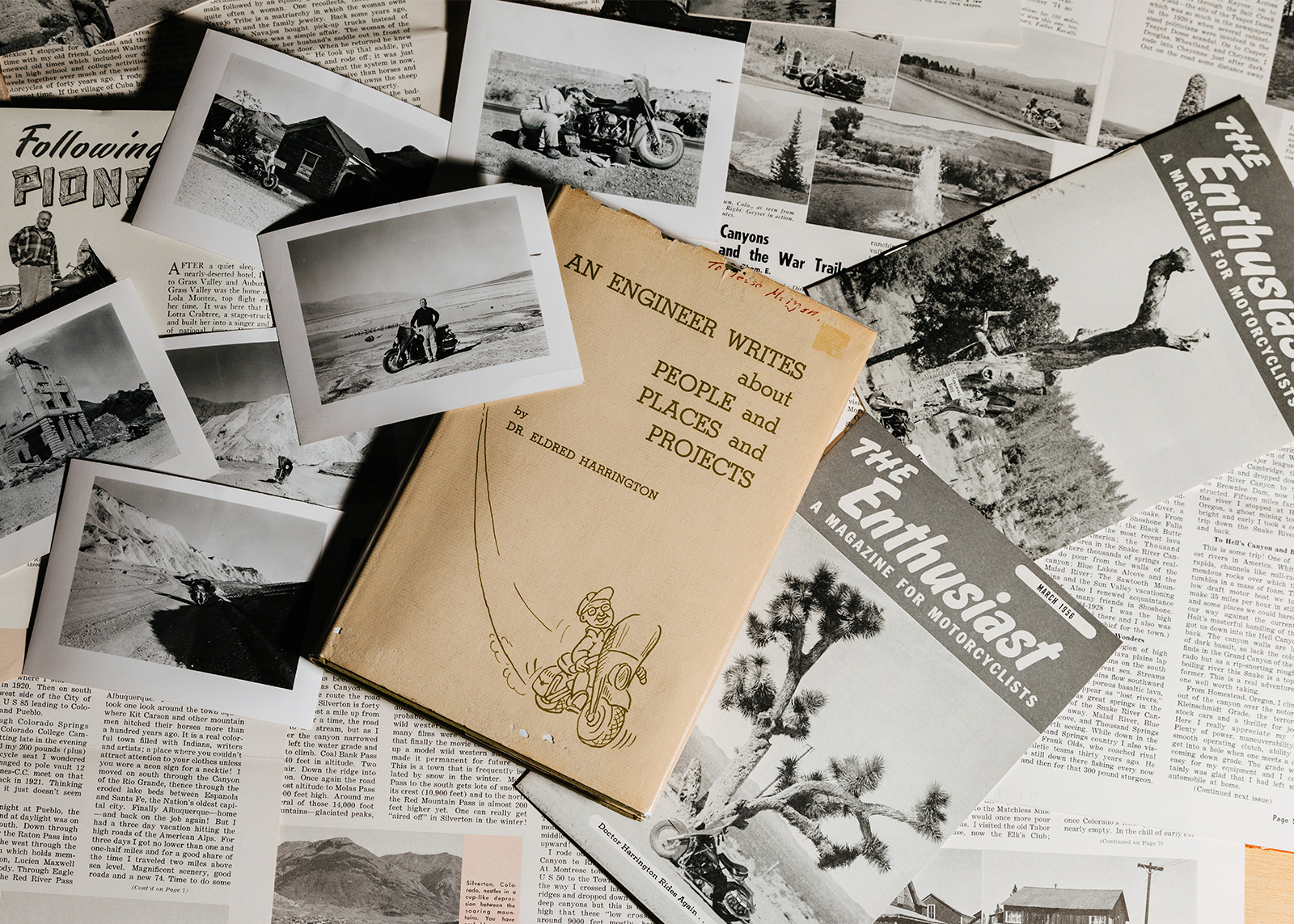 Collection of vintage black-and-white motorcycle photos, magazines titled The Enthusiast, and a book titled An Engineer Writes about People and Places.