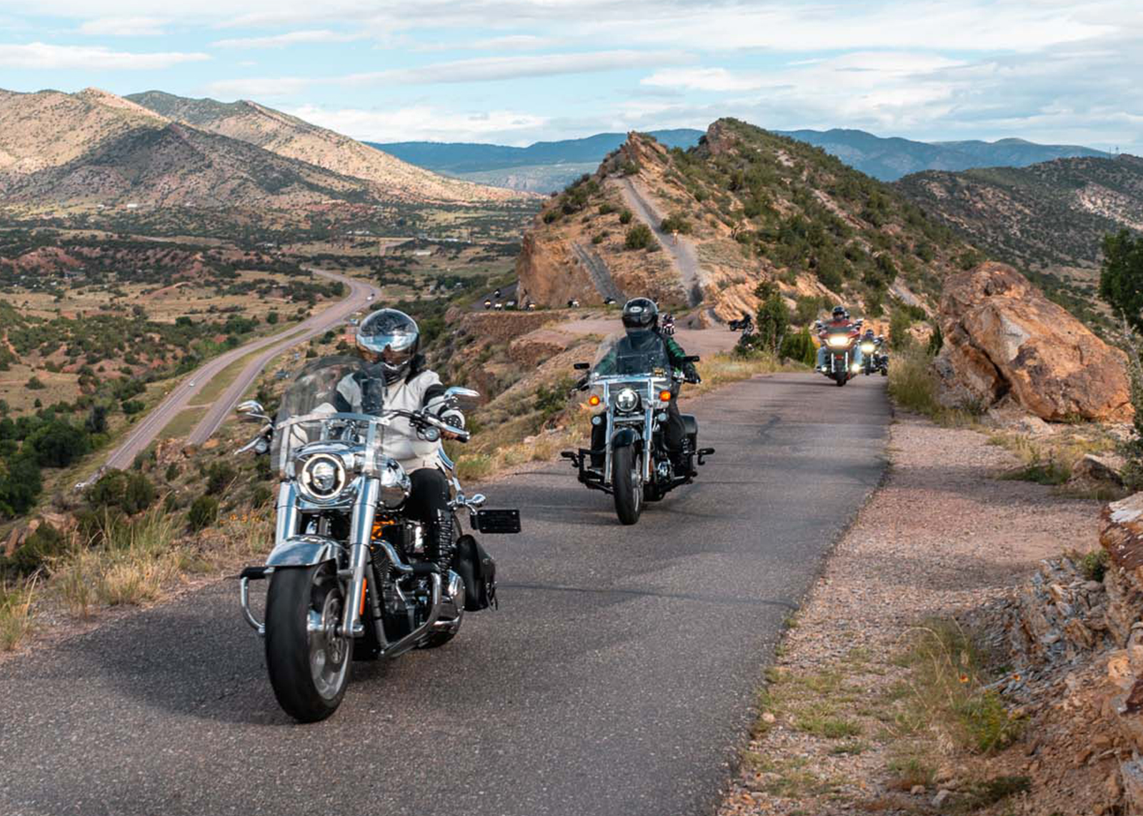 Harley-Davidson riders travel on a narrow stretch of one-way road along a mountain ridge on Skyline Drive near Cañon City, Colorado.