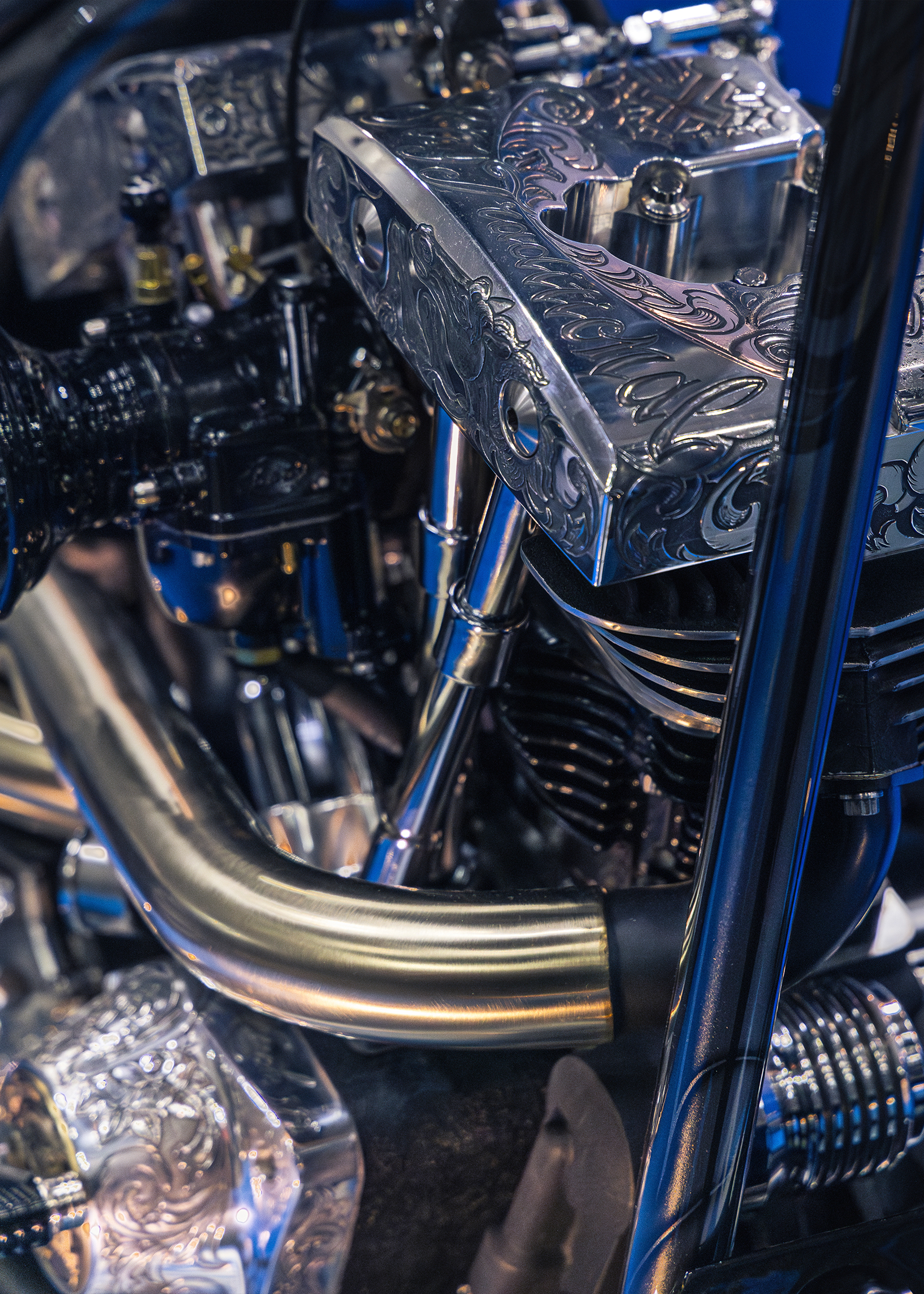 Close-up of a custom motorcycle engine featuring polished metal parts and intricate engraved detailing