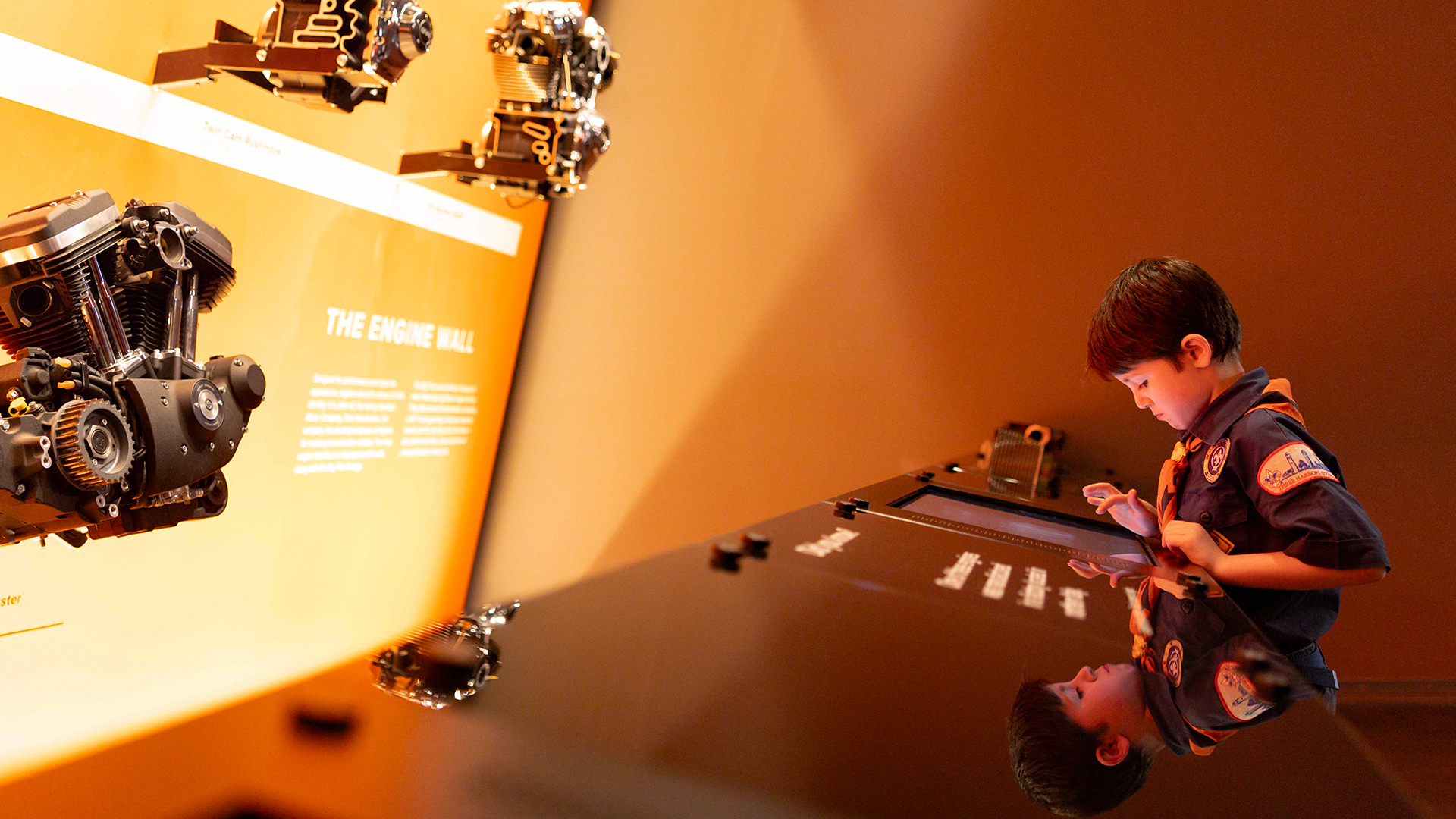 Child interacting with engine components at museum exhibit