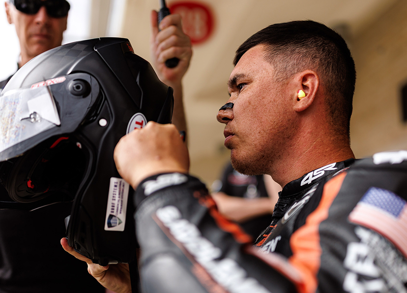 Rider puts on his helmet in the paddock before heading out to the track