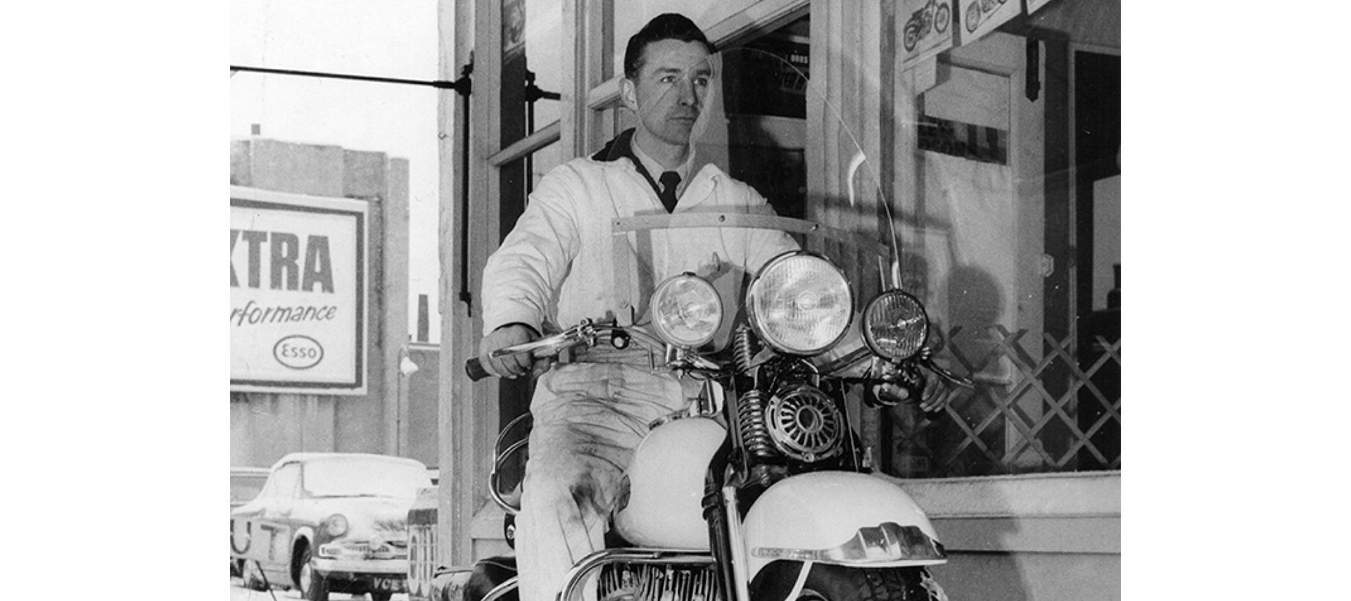 A man sits on a parked motorcycle