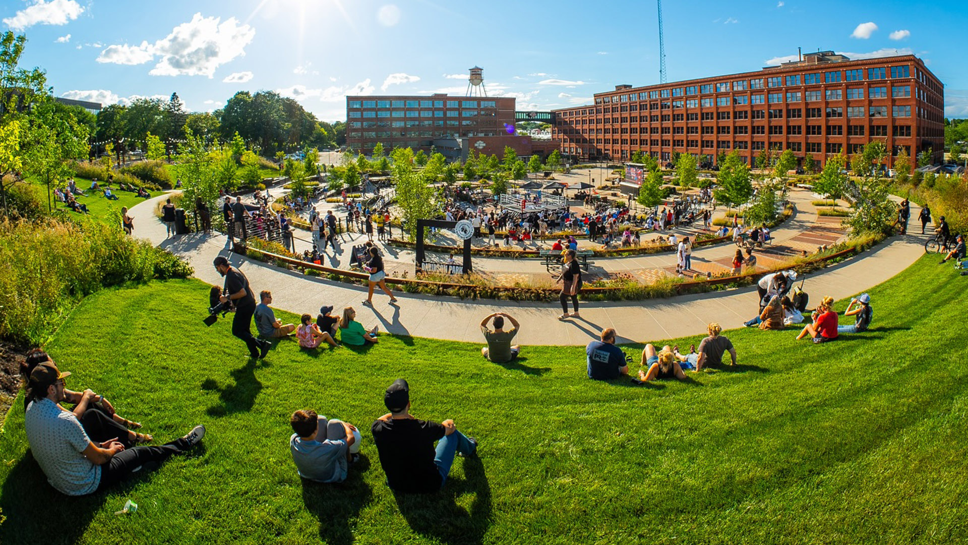People sitting and walking around a large outdoor park and plaza