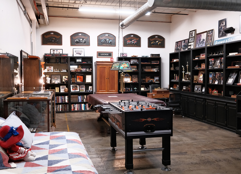 Harley-Davidson lounge area with foosball table, display shelves, vintage memorabilia, and framed wall decor