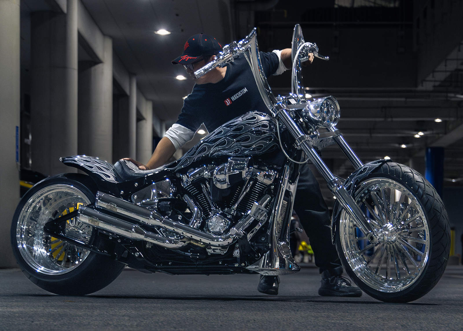 A builder stages his custom motorcycle with white flame paint and chrome details