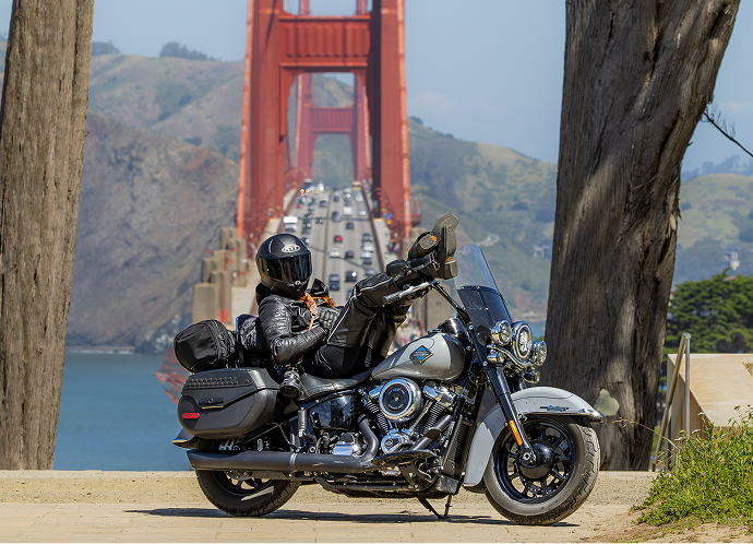 Motorcycle parked roadside with rider leaning back on seat and Golden Gate Bridge in background