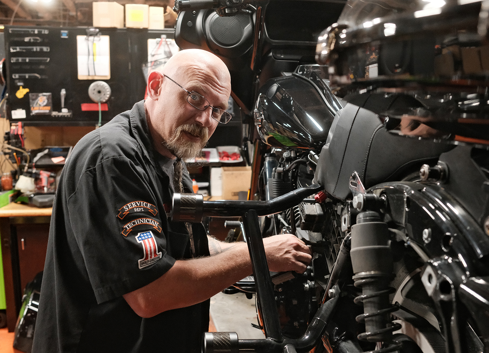Man O’ War Harley-Davidson dealership technician performs maintenance on a motorcycle in the service shop