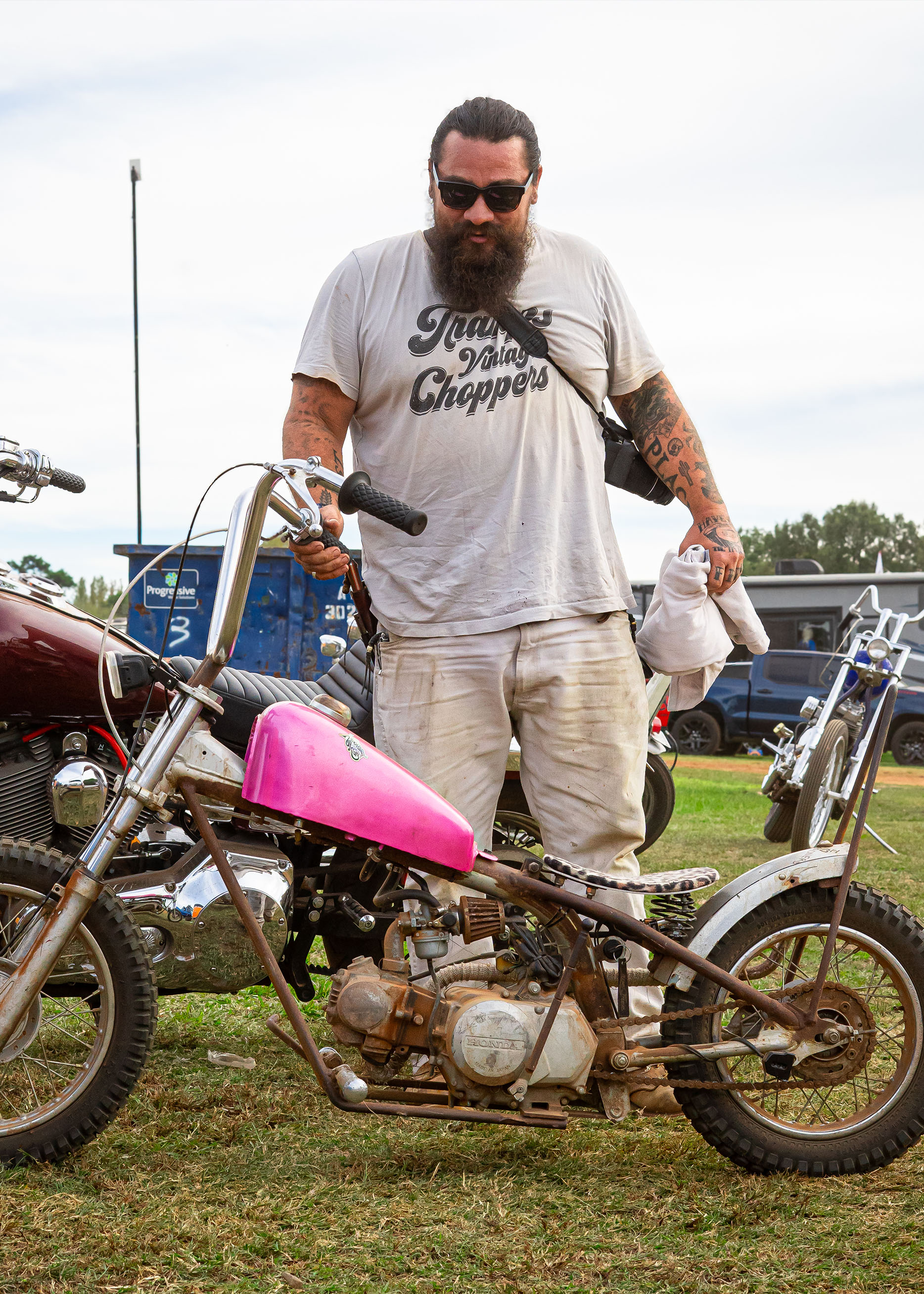 Man standing over a small pink bike